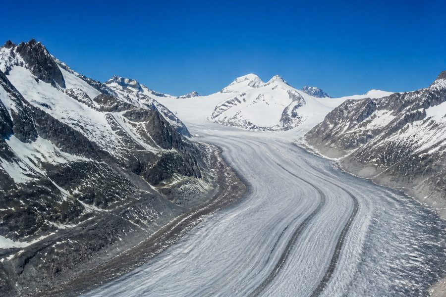 El glaciar Aletsch visto desde lo alto, un enorme río de hielo con franjas oscuras que se pierde entre cumbres nevadas