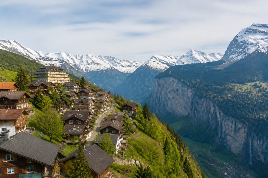 El pueblo de Wengen sobre la ladera del valle de Lauterbrunnen, con casas de madera y montañas nevadas al fondo