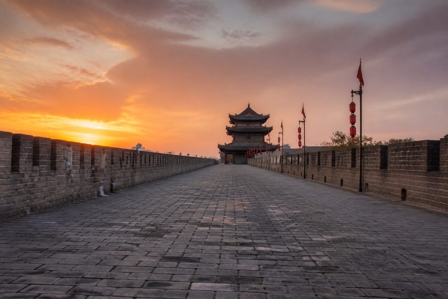 La muralla medieval de Xi'an vista desde su paseo superior, con las almenas a los lados y una torre al fondo