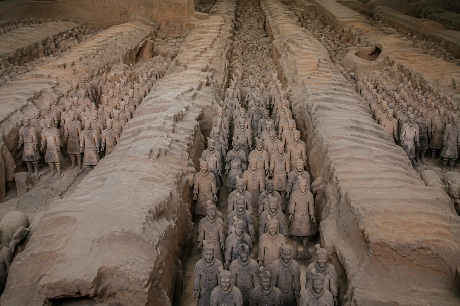 Filas de guerreros de terracota a tamaño real alineados en los corredores de tierra de la fosa excavada de Xi'an