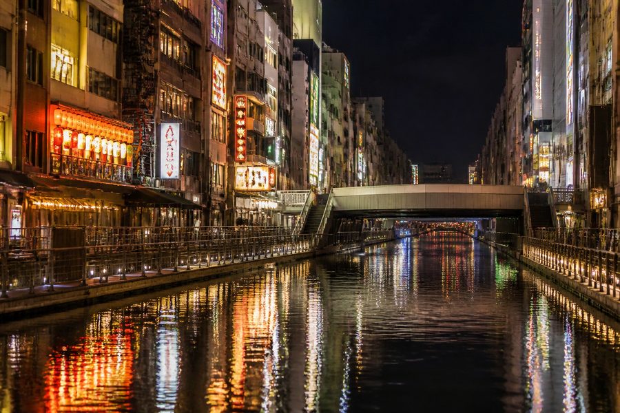 El canal de Dotonbori de noche, con las luces de los restaurantes reflejándose en el agua